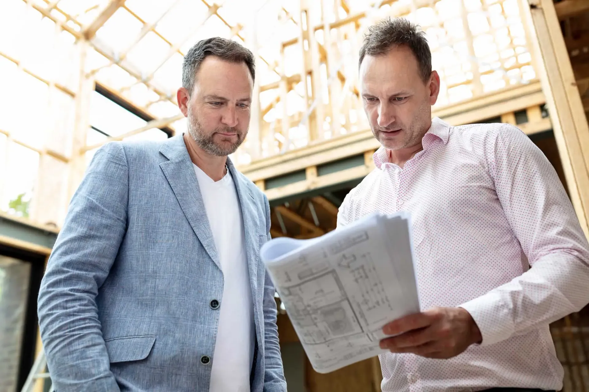 Two architects reading plans onsite at a new build architecture photography.