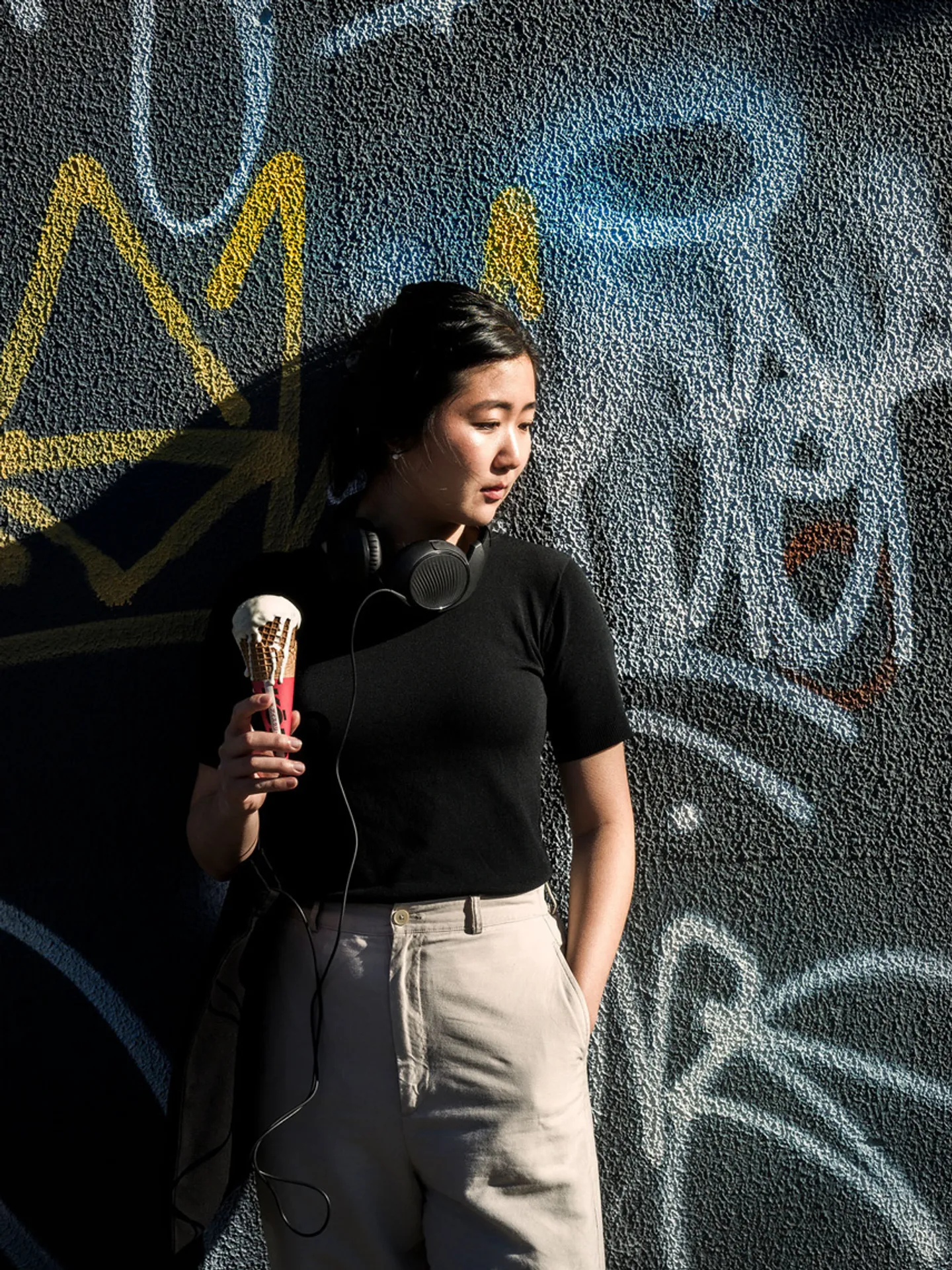 Kori ice person eating ice-cream from cone in laneway opposite Luminous Studios in South Melbourne.